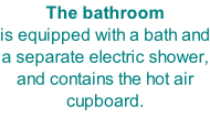 The bathroom is equipped with a bath and a separate electric shower, and contains the hot air cupboard.